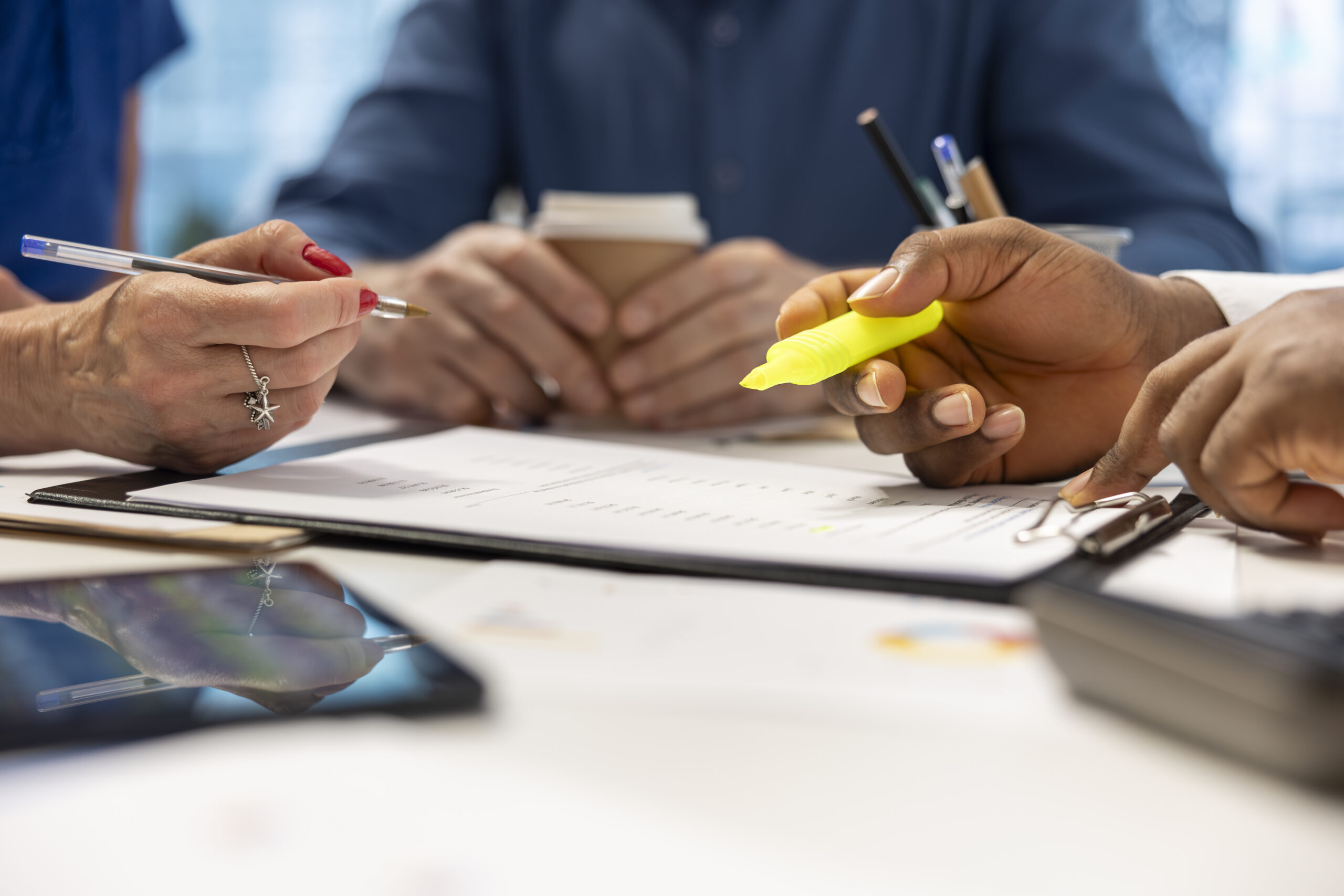 Financial advisor expert highlighting important terms on retirement plan contract, discussing finances and investments to secure life savings. Broker assisting mature couple. Close up.